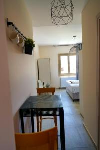 een kamer met een tafel en stoelen en een slaapkamer bij Charikleia's 2 bedroom appartment in Pelion in Volos