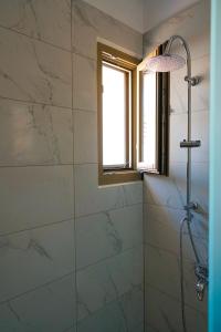 een badkamer met een douche en een raam bij Charikleia's 2 bedroom appartment in Pelion in Volos
