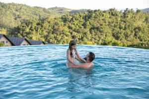 Ein Mann und ein kleines Mädchen im Wasser in der Unterkunft Resort Ecoar in Gaspar