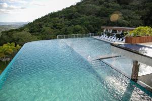 una piscina d'acqua con una montagna sullo sfondo di Resort Ecoar a Gaspar