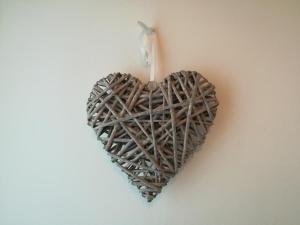 un corazón de madera colgando de una pared en B & B Color Rovereto, en Rovereto