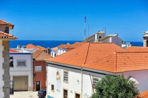a group of buildings with orange tile roofs at Casa das Escadinhas in Ericeira