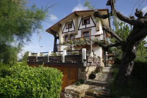 a house with a porch and a wooden fence at 2 HABIT, SALA, TERRAZA, JARDIN, PARKING GRATiS in Zumaia