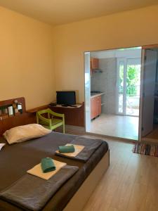 a bedroom with a bed with two green towels on it at Seafront aparment in Podgora
