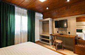 Uma TV ou centro de entretenimento em Hotel Fioreze Chalés