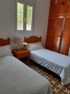una camera con due letti e un tavolo con una lampada di Casa rural Los Dragos a Fuencaliente de la Palma