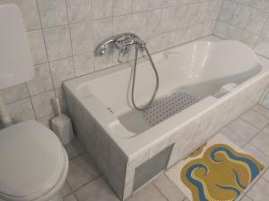 a white bathroom with a tub and a toilet at Simos Apartments in Korinos +180 photos