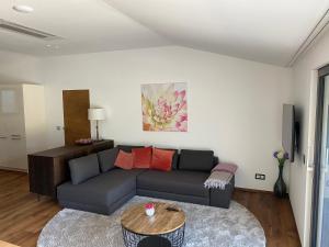 ein Wohnzimmer mit einem Sofa und einem Tisch in der Unterkunft Modern Living Sankt Gilgen in Sankt Gilgen