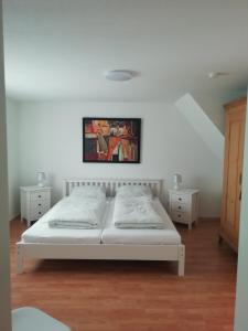 a bedroom with two beds and a painting on the wall at Stadthaus Kaufbeuren in Kaufbeuren