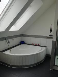 uma grande banheira branca num quarto em Stadthaus Kaufbeuren em Kaufbeuren