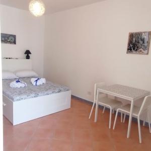 a white bedroom with a bed and a table at I 23 PASSI GAETA in Gaeta