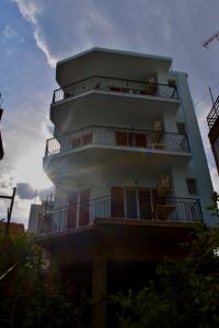 un bâtiment avec deux chiens assis sur les balcons dans l'établissement Bob's Apartments, à Tolón