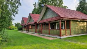 une rangée de cottages avec des toits rouges dans l'établissement Wiśniowy Sad - Domki, à Białowieża