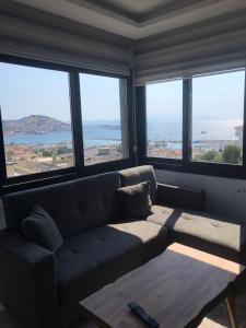 een woonkamer met een bank en grote ramen bij Riva Marina in Kuşadası