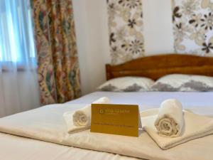 a hotel room with towels and a sign on a bed at Gemini House ULTRACENTRAL 3 margarete in Costinesti