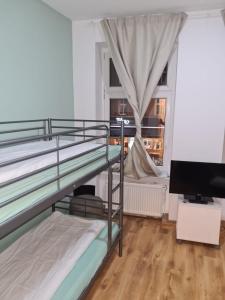 a bedroom with two bunk beds and a flat screen tv at Hotel hostel Zafir in Berlin