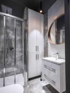 a bathroom with a shower and a sink and a mirror at Luxo apartments 13 in Jelenia Góra