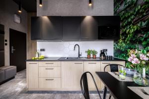 a kitchen with a sink and a table with chairs at Luxo apartments 13 in Jelenia Góra