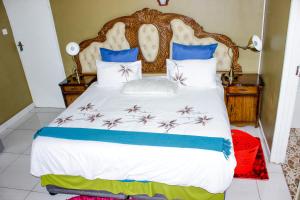 a bedroom with a large bed with blue and white pillows at Motseleng Guest House in Palatswe