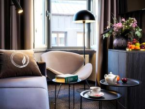a living room with a couch and two tables at Hotel Logos Kraków in Krakow