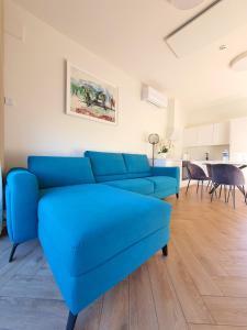 ein blaues Sofa im Wohnzimmer mit einem Tisch in der Unterkunft SEA PEARL Holiday home, Mano jūra 1, Kunigiškiai in Kunigiškiai