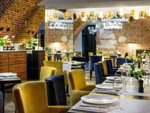 a dining room with tables and yellow chairs at Hotel Logos Kraków in Krakow