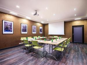 a conference room with tables and chairs and a whiteboard at Hotel Logos Kraków in Krakow