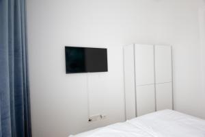 ein Schlafzimmer mit einem Bett und einem TV an der Wand in der Unterkunft Studio Apartments Opera - Mai's Apartments - by Arbio in Wien