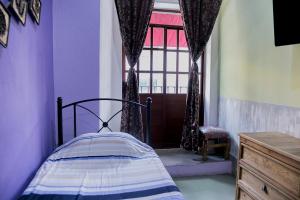 a small bedroom with a bed and a window at Hotel el Descanso in Puebla