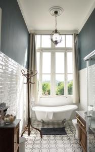 a bath tub in a bathroom with a window at La Venta de Miyares - Casa de Indianos in Piloña +78 photos