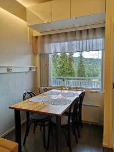 a dining room table with chairs and a large window at Ruka - Vuosselin Helmi B21 in Ruka