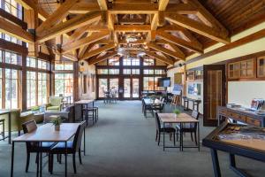 una sala da pranzo con tavoli, sedie e finestre di New Listing In The NEW Signature Collection At Old Greenwood! a Truckee