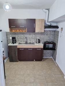 a kitchen with brown cabinets and a sink at Titika's House in Skiathos Town