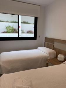 two beds in a room with two windows at Luxury sea view MARGOAPARTMENTS in Gran Alacant