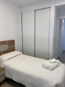 1 dormitorio con 2 toallas blancas en una cama en Luxury sea view MARGOAPARTMENTS, en Gran Alacant