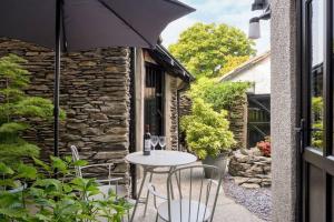 a table and chairs on a patio with an umbrella at The Court Yard in Bowness-on-Windermere