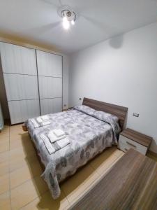 um quarto com uma cama grande e toalhas em AM apartment em Olbia