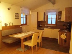 eine Küche mit einem Holztisch und gelben Stühlen in der Unterkunft Ferienwohnung Gassoid in Fieberbrunn