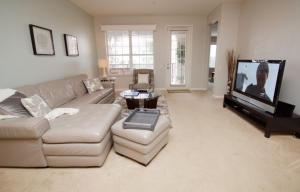 a living room with a couch and a flat screen tv at Shoreway Condo #231521 in Orlando