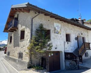 um edifício com uma árvore em frente em Chalet Nicolin em Livigno