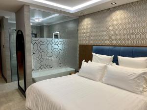 Un dormitorio con una cama grande y una bañera. en Nare Boutique Hotel, en Kimberley