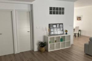 Una sala de estar blanca con una puerta y una mesa. en Piso nuevo, céntrico y tranquilo, en Bullas 7 fotos más