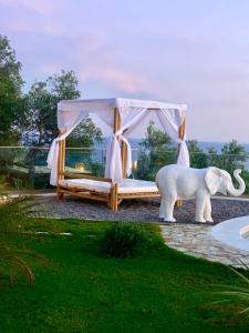 a statue of an elephant standing next to a bed at PARGA Villas Collection in Parga
