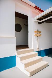 uma escada numa casa com um sinal na parede em Zulla Nazaré`s Surf Village em Nazaré