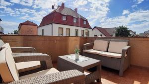 a patio with two chairs and a table and a building at Sea&Wine Apartamenty Darłówko in Darlowko