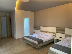1 dormitorio con 2 camas y espejo en Imperial Hotel, en Shënkoll