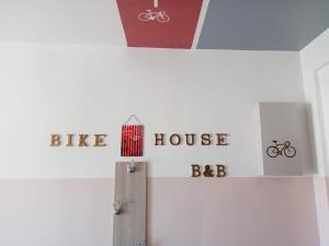 een witte kamer met een fietsenstalling en borden op de muur bij BIKE HOUSE 3 "gold" in Seriate