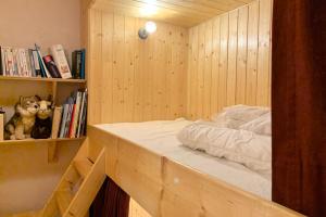 uma cama num quarto de madeira com uma estante de livros em The Chamroussian #BU em Chamrousse