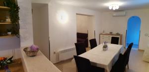 a dining room with a white table and black chairs at Holiday Home Korkyra Sunrise in Korčula