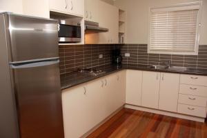 a kitchen with a stainless steel refrigerator and white cabinets at Yabbaloumba Retreat in Booloumba